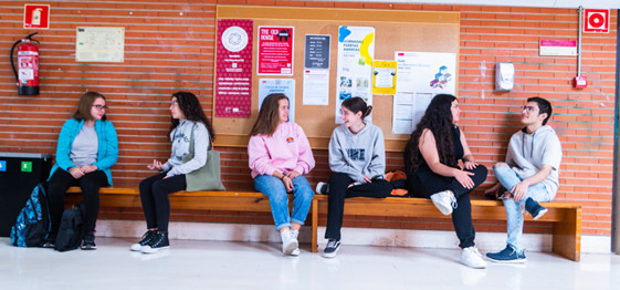 Estudiantes sentados en el hall de la Facultad