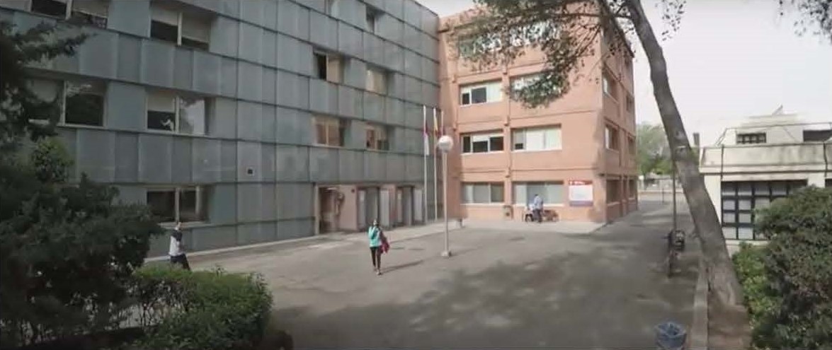 Fachada del edificio Lorenzo Luzuriaga visto con perspectiva - lateral del edificio con un alumno paseando 