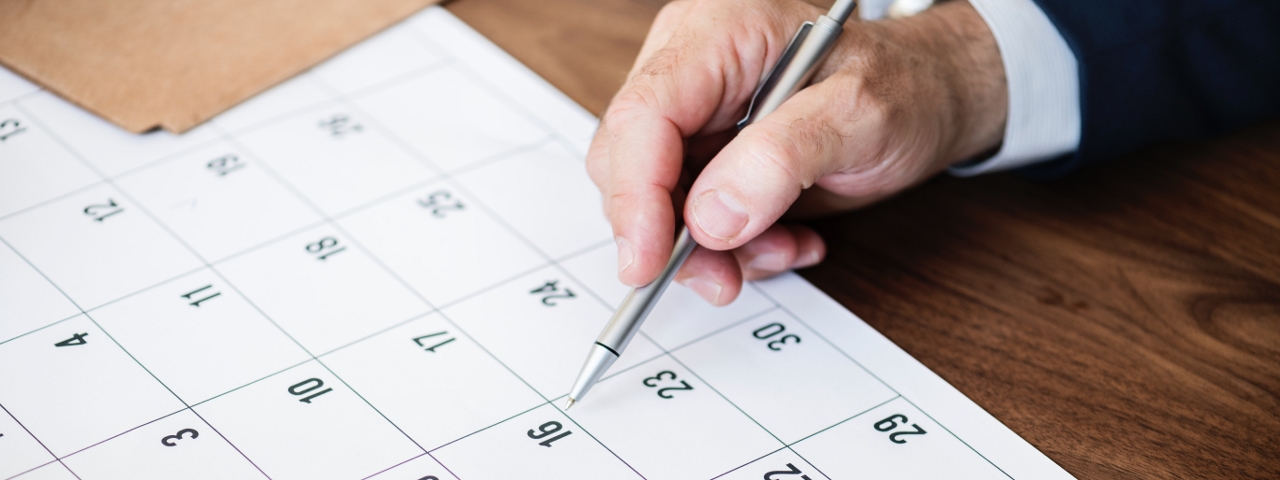 una hoja de un calendario  - una mano sosteniendo un bolígrafo apuntando hacia el número 16