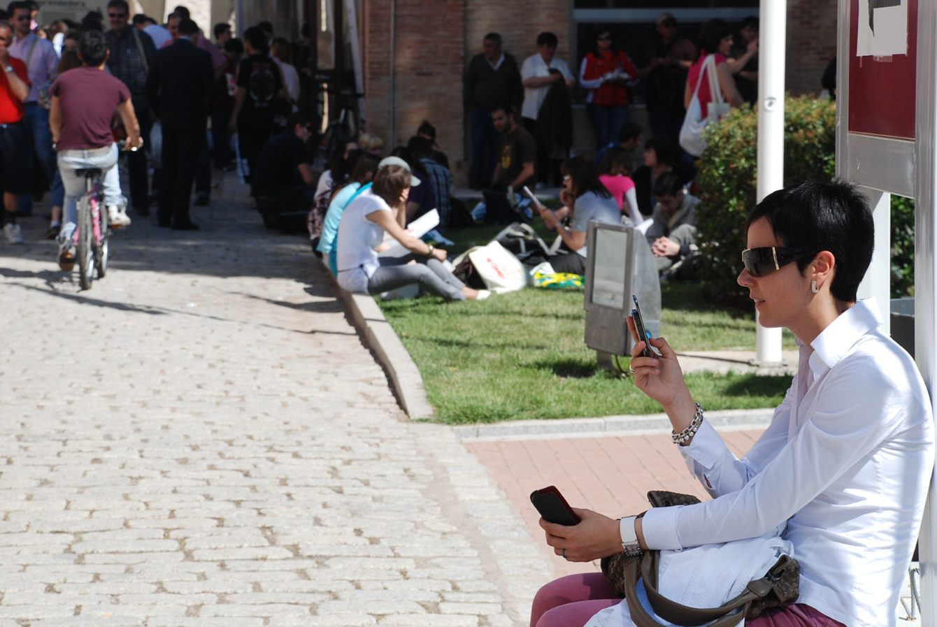 Una estudiante consulta su móvil en el Campus de Toledo