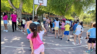 Un grupo de niños y niñas juega en las pistas deportivas