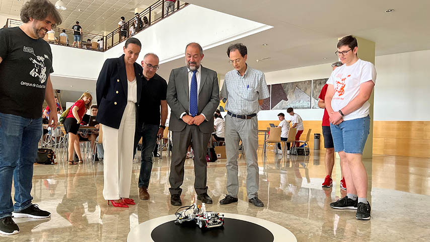 El rector, la alcaldesa, y los profesores Feliu y Ramos observan dos robots en un combate de sumo