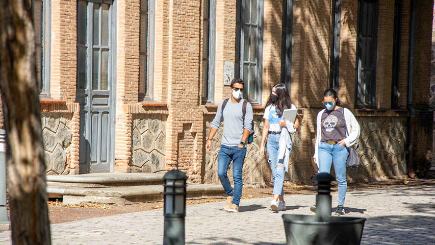 Tres estudiantes pasean  por el campus de Toledo
